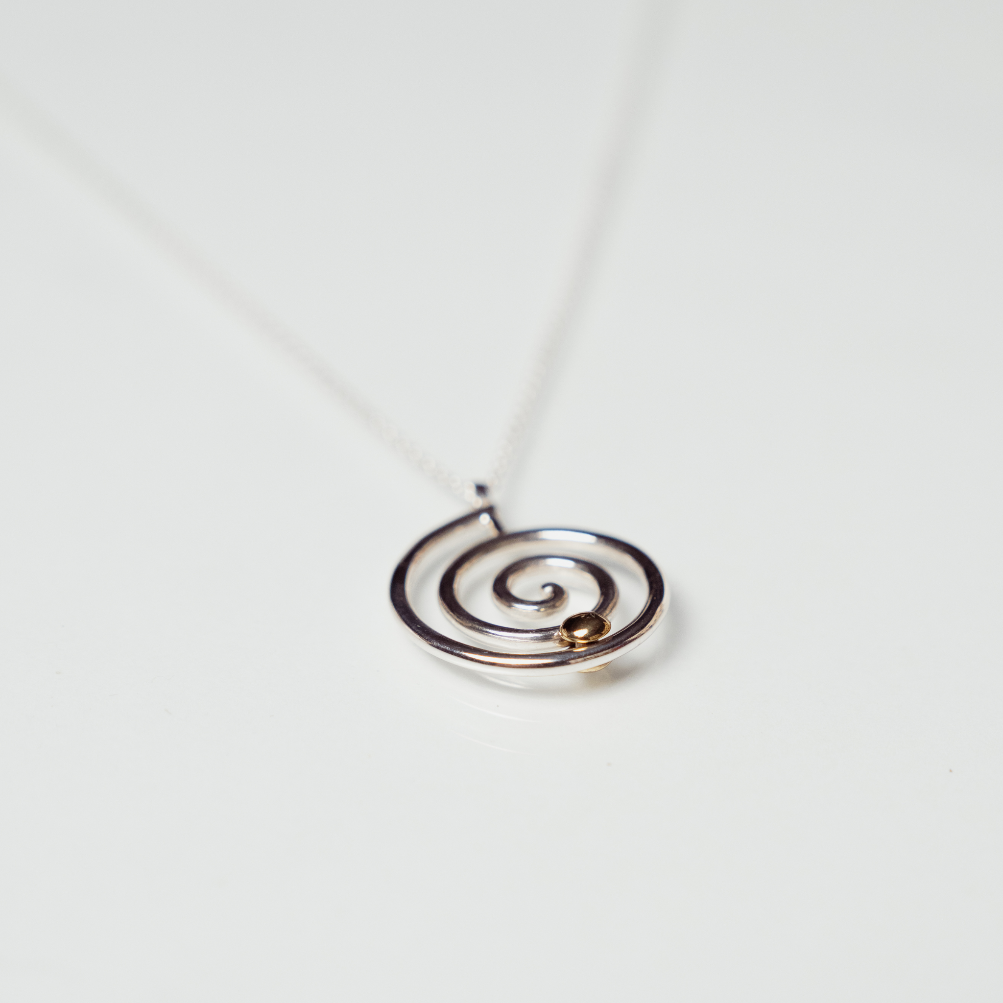 The Kirstie necklace anxiety necklace with silver spiral and bronze ball on white background