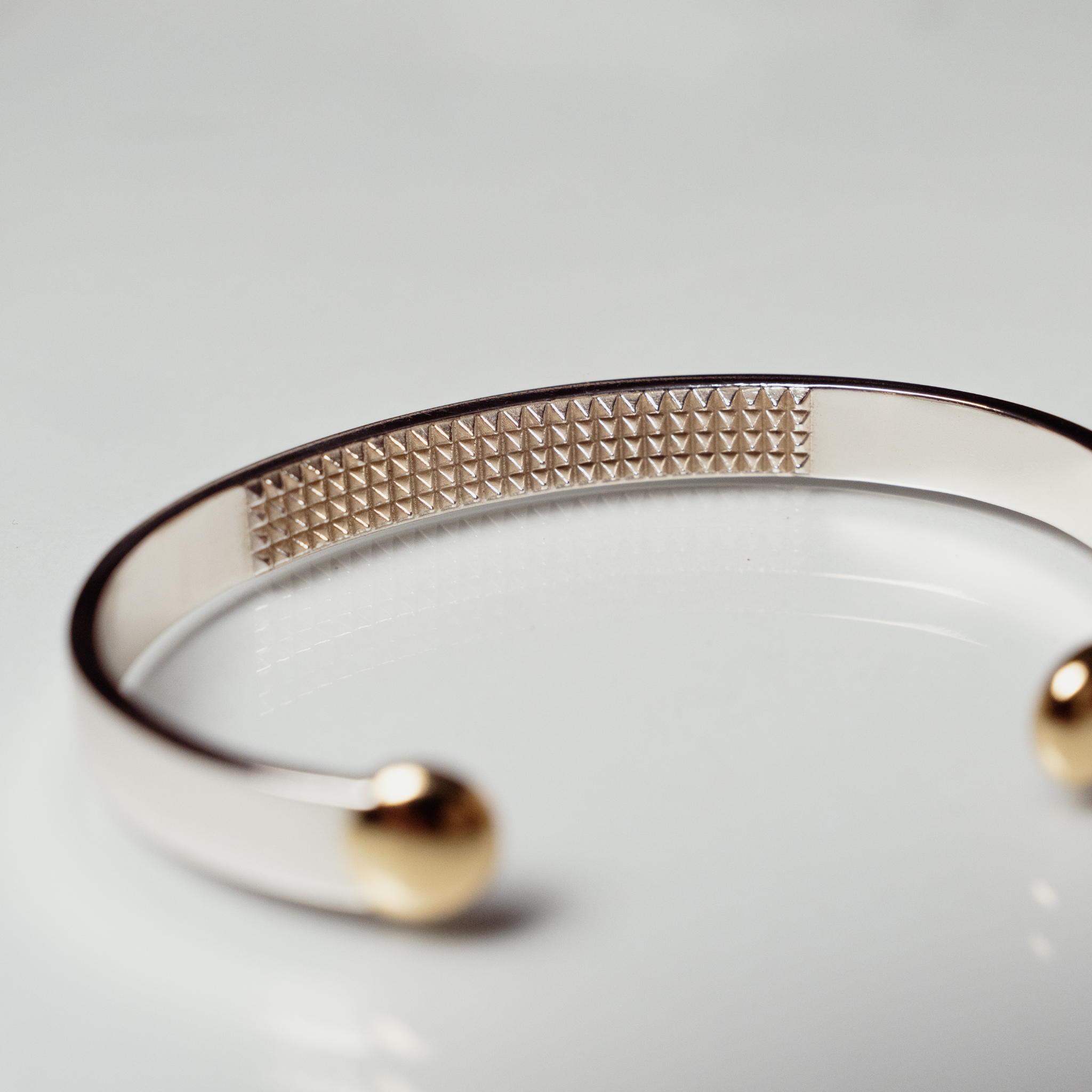 The Annika cuff anxiety bracelet showing textured inside section in silver and bronze on white background