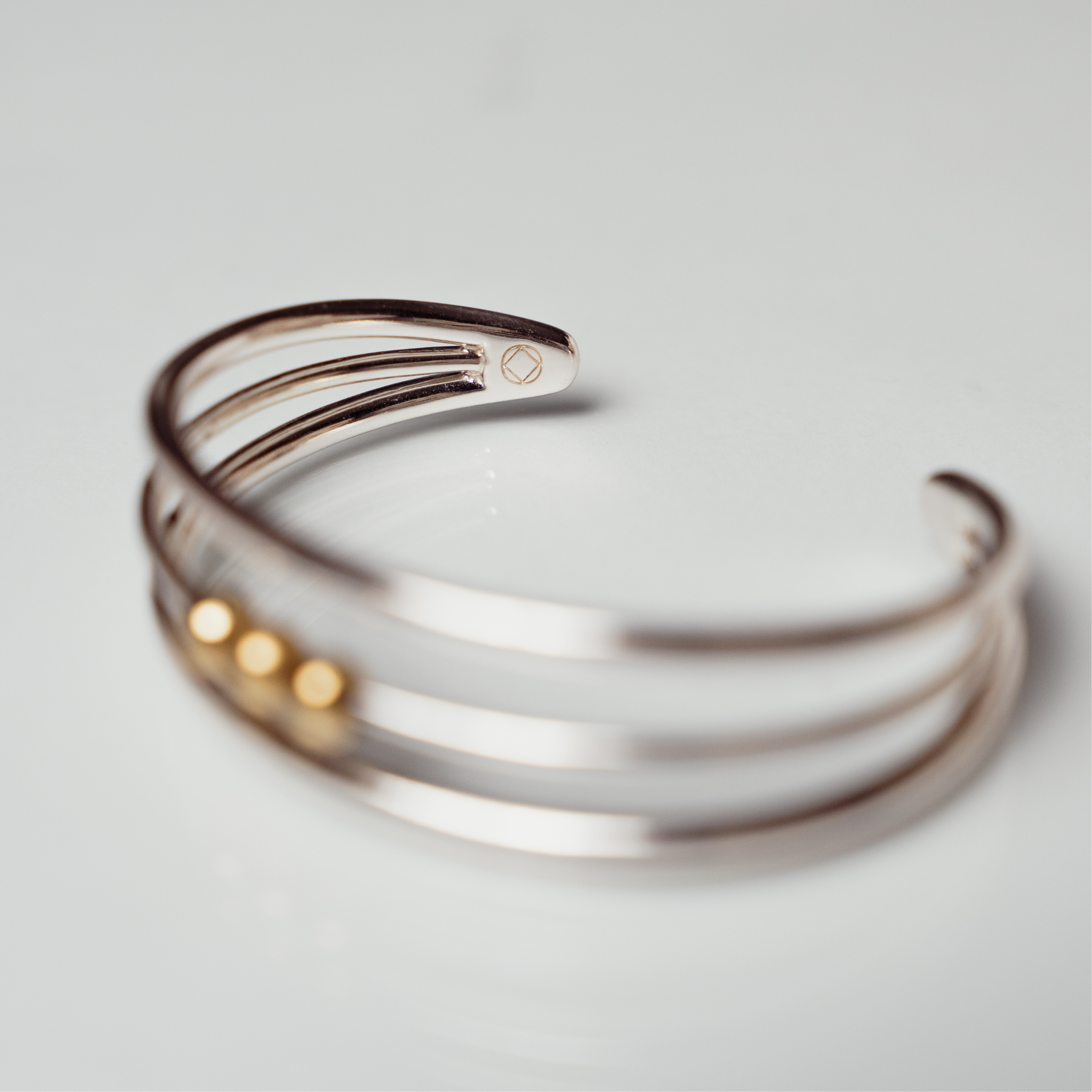 The Winda bangle anxiety bracelet silver with bronze balls on white background