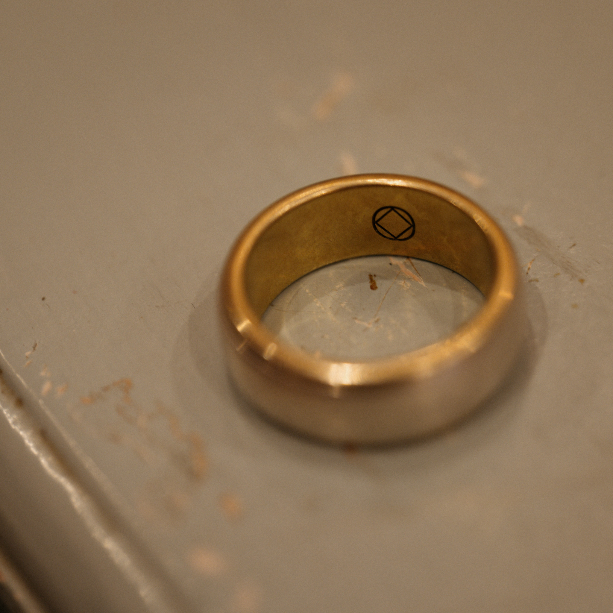 The Jake ring anxiety ring with bronze inside and silver spinning ring on outside on wooden table